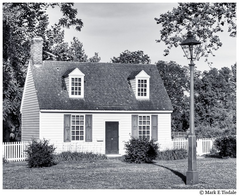 Black and white photo of a house with a White Picket Fence - Williamsburg, Virginia