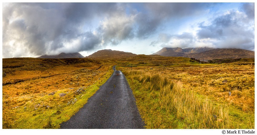 Panorama Photo of a road heading to the horizon in the landscape of Connemara 