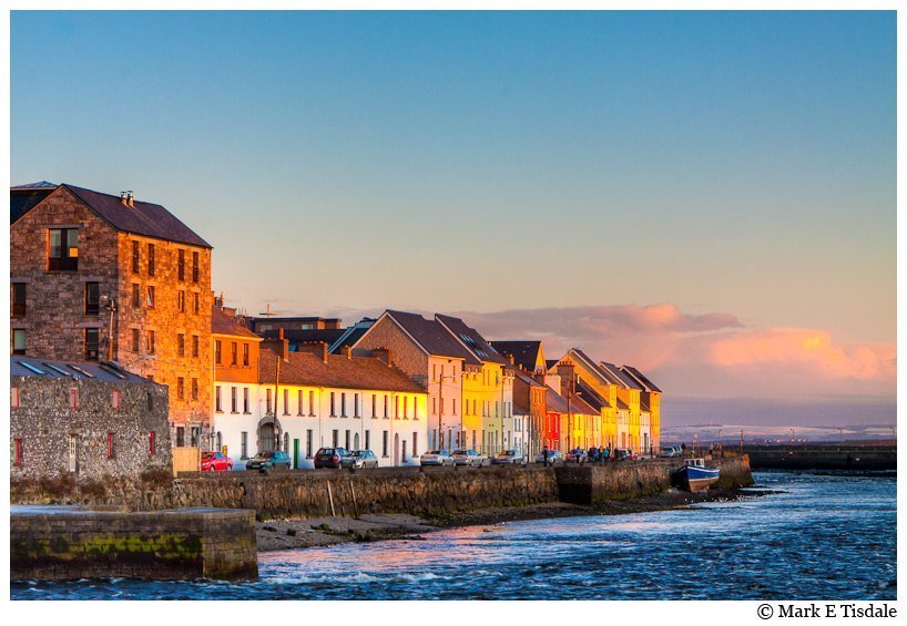 Photo of colorful houses on the seaside in the warm sunlight in Galway Ireland