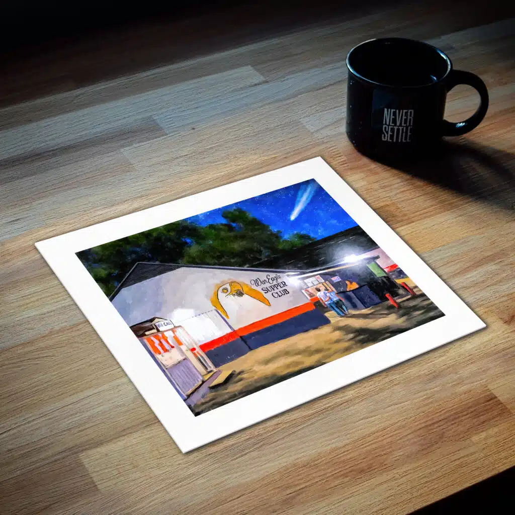 Art Print of the War Eagle Supper Club lying on a wood desk